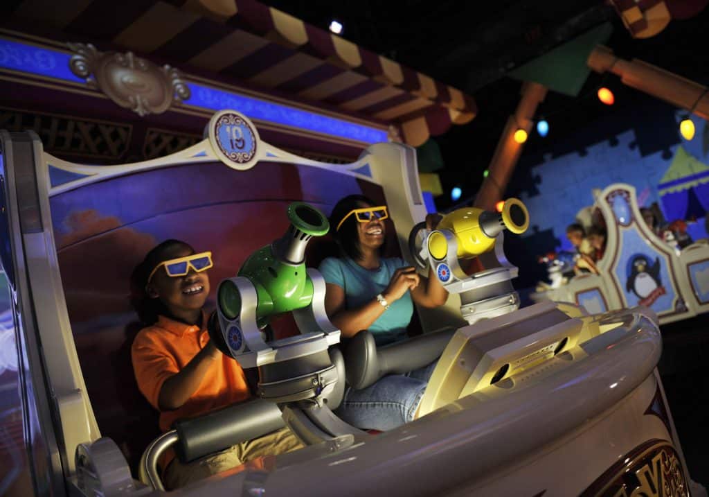 Vehículo de Toy Story Mania! con pasajeros a bordo. Cada uno tiene su pistola, una verde y una amarilla, para diferenciar sus tiros en las pantallas unos de otros. Es una de las atracciones de Hollywood Studios