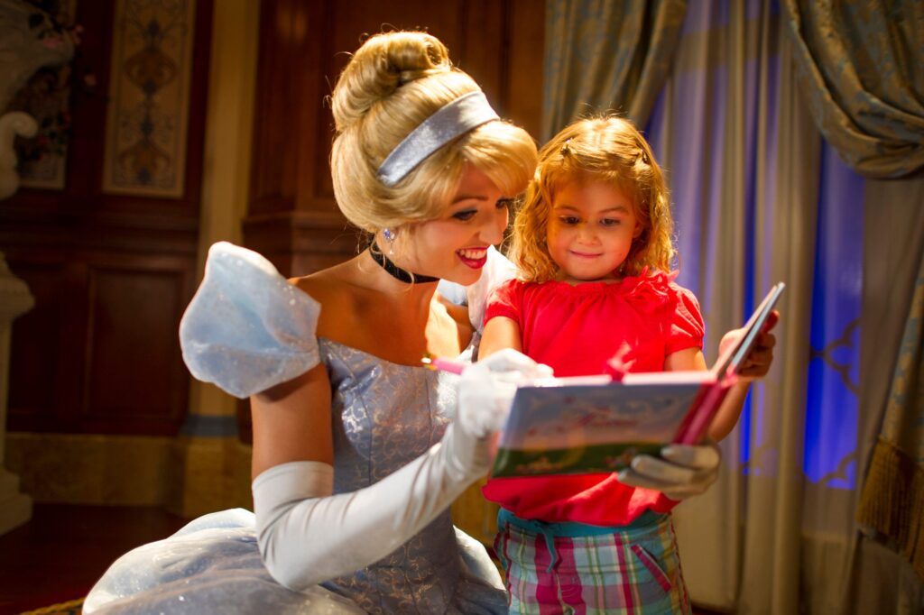 La Cenicienta en Princess Fairytale Hall firmando un autógrafo para una niña pequeña. Esta es una de las experiencias más bonitas al conocer personajes en Disney World