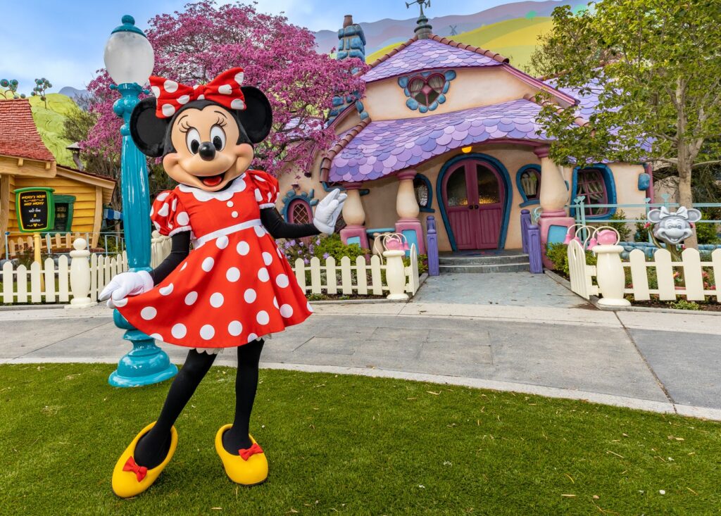 Minnie Mouse con su clásico vestido rojo con puntos blancos afuera de su casa en Mickey's Toontown