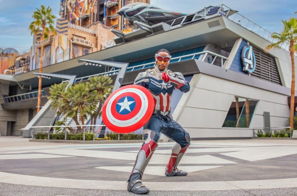 Avengers Campus en Disney California Adventure es otra de las zonas de películas en los parques de Disney. En la imagen aparece capitán américa con su traje y al fondo el cuartel general de Avengers en el parque de diversiones
