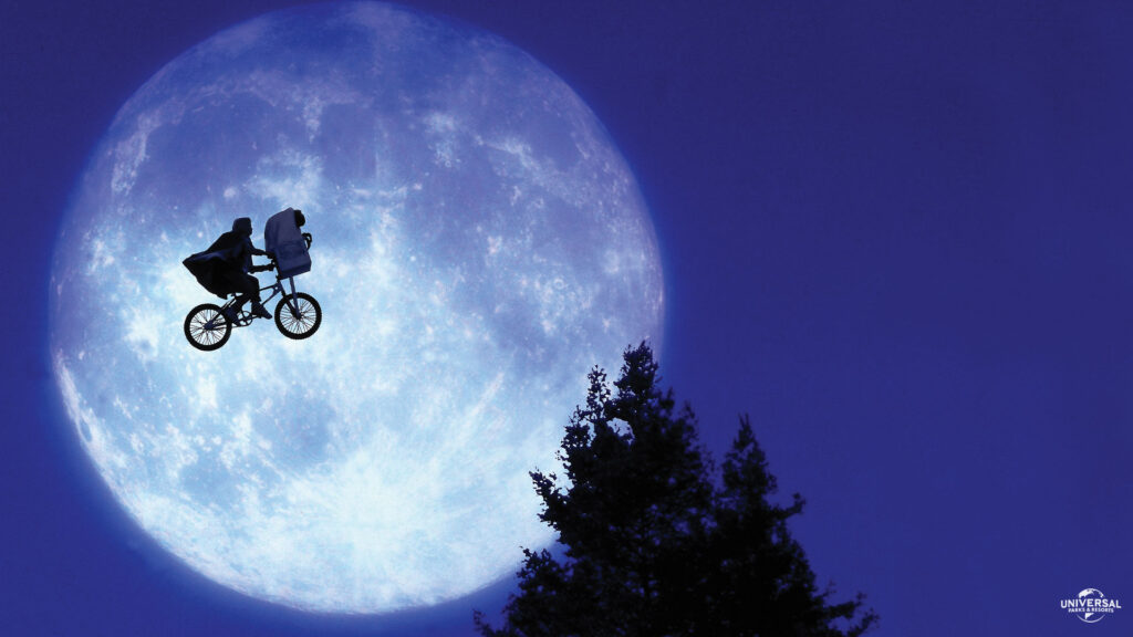 Famosa escena de E.T. en la que el protagonista vuela en su bicicleta pasando frente a la luna con E.T en su canastilla. Película que inspiró una de las atracciones familiares de Universal Orlando 